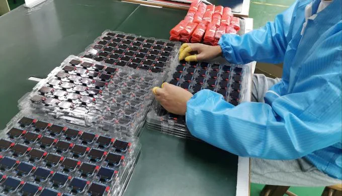 Operator loading display modules into blister trays